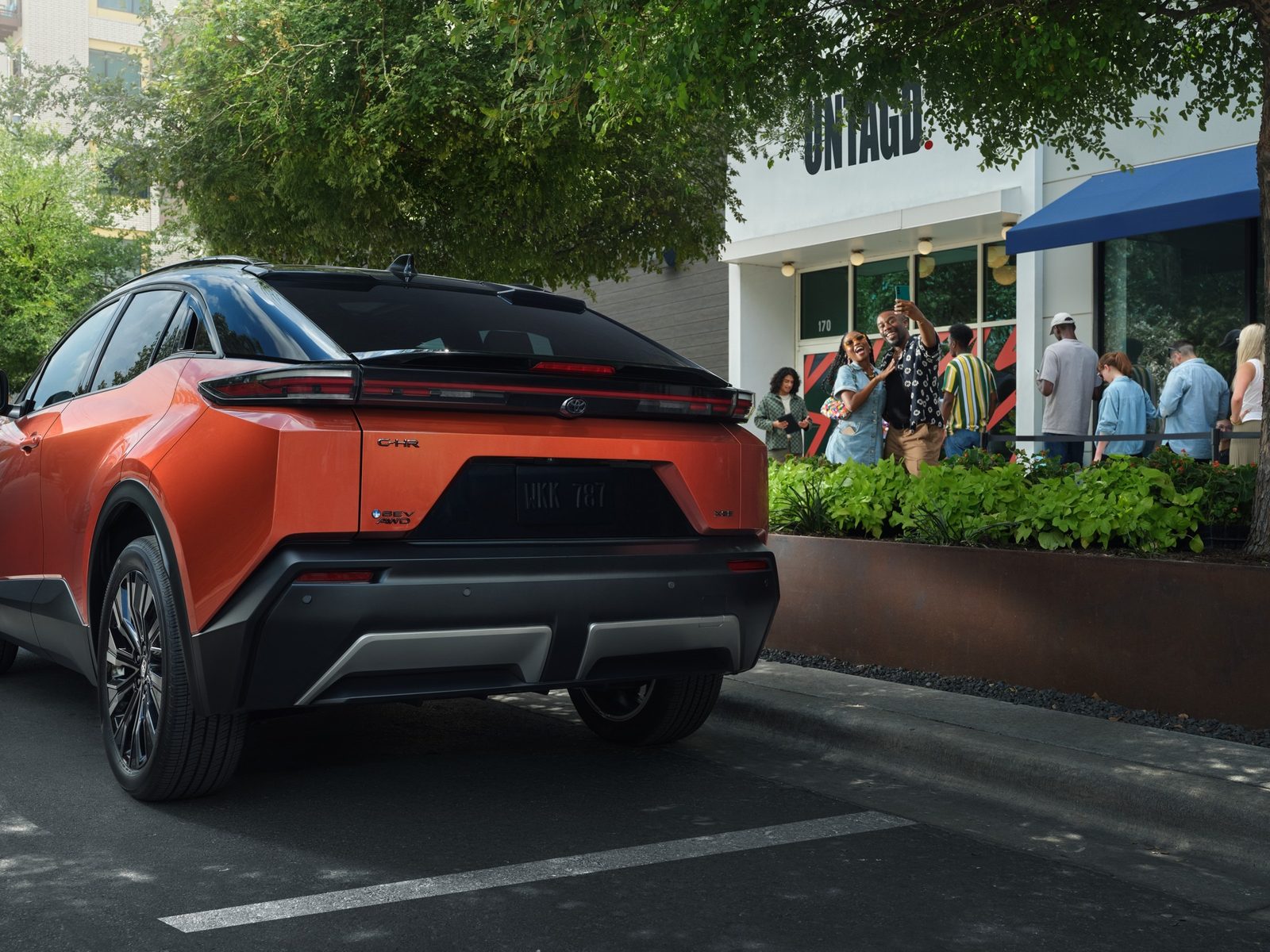 Toyota C-HR EV 2026 — экстерьер, rear 3q orange, рынок US / EU reference